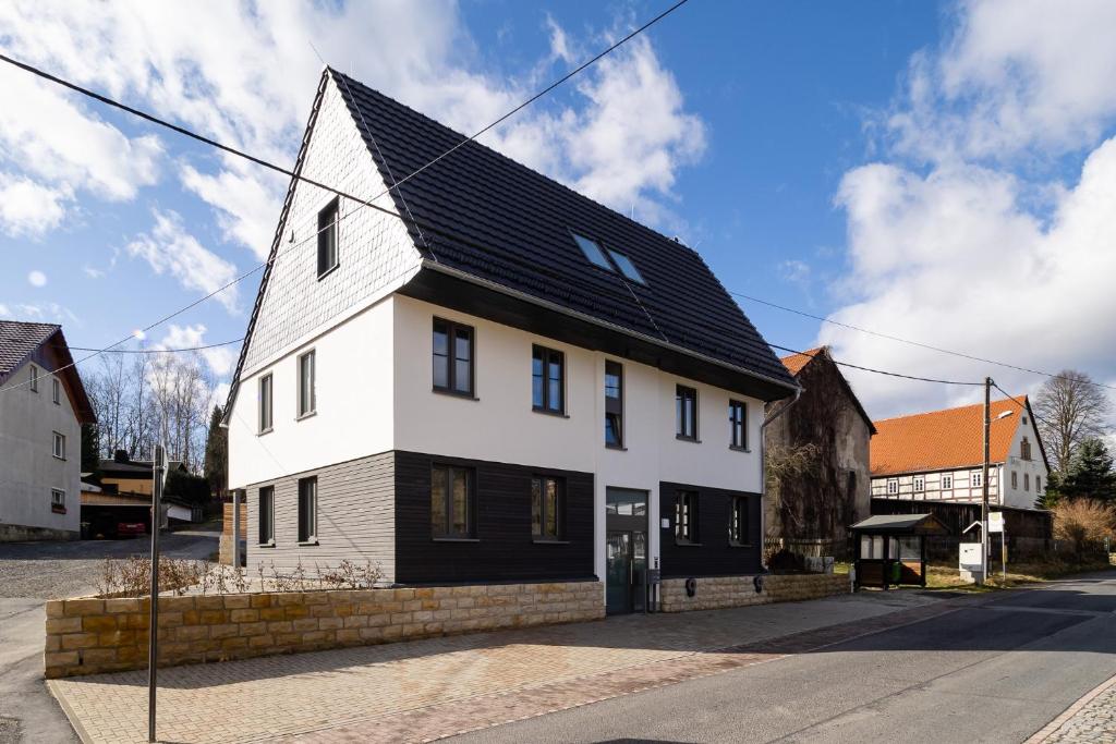 卡劳特格瑞斯赫Neues Ferienhaus的街上有黑屋顶的白色房子