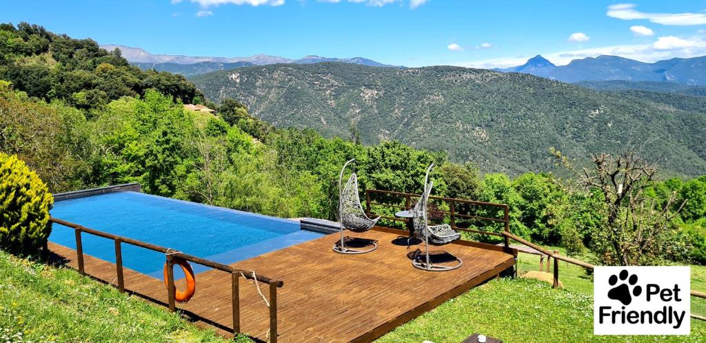Vall de Bianya马斯普拉特乡村Spa酒店的山景木制甲板上的游泳池