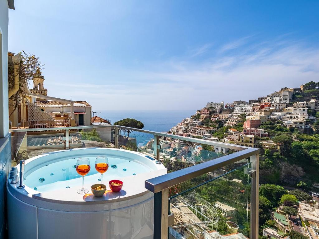 波西塔诺Santoro Suite的阳台设有热水浴池,提供2杯葡萄酒