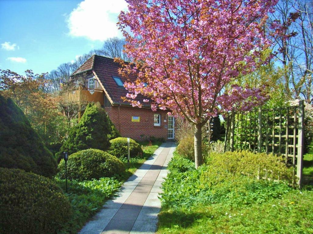 巴特多布兰Ostsee Hotel-Pension An der Lindenallee的房子前有粉红色花的树
