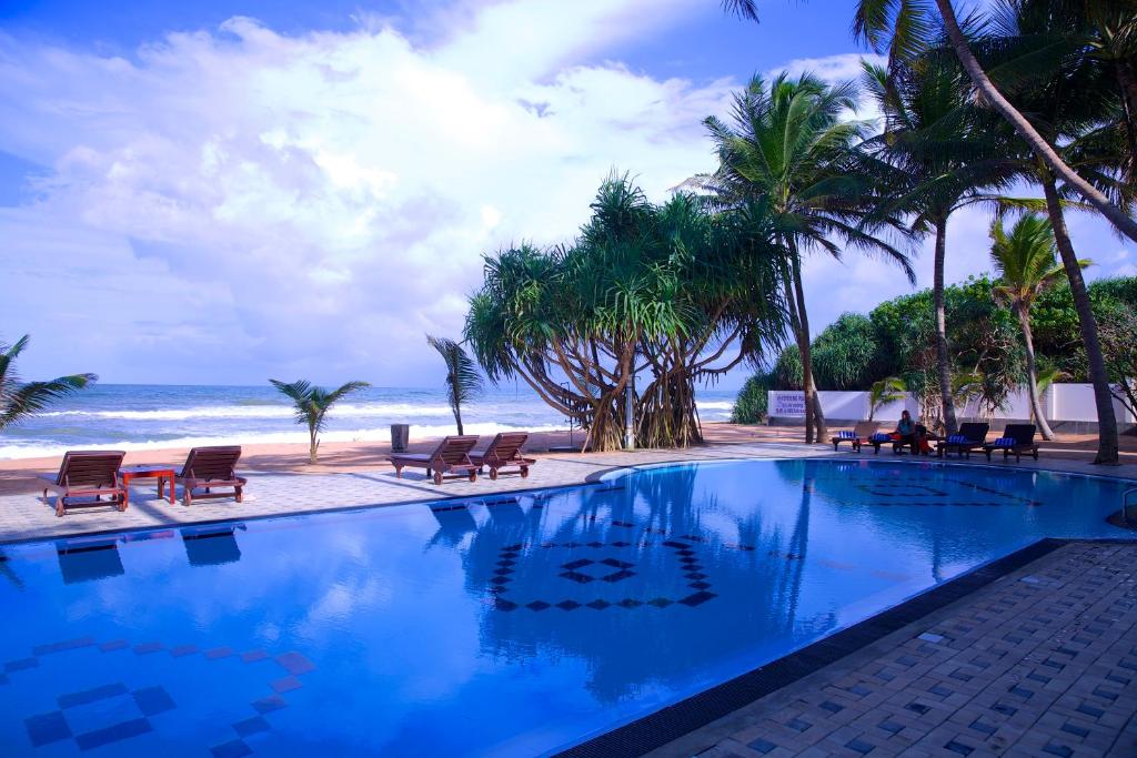 本托塔棕榈语酒店的棕榈树海滩旁的游泳池
