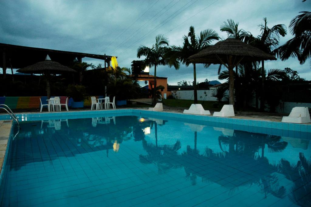 卡纳内亚Hotel Marina Clube de Pesca的一个带椅子和遮阳伞的大型游泳池