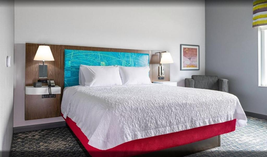 拉瓦卡港Hampton Inn & Suites Port Lavaca, Tx的酒店客房带一张大床和一把椅子