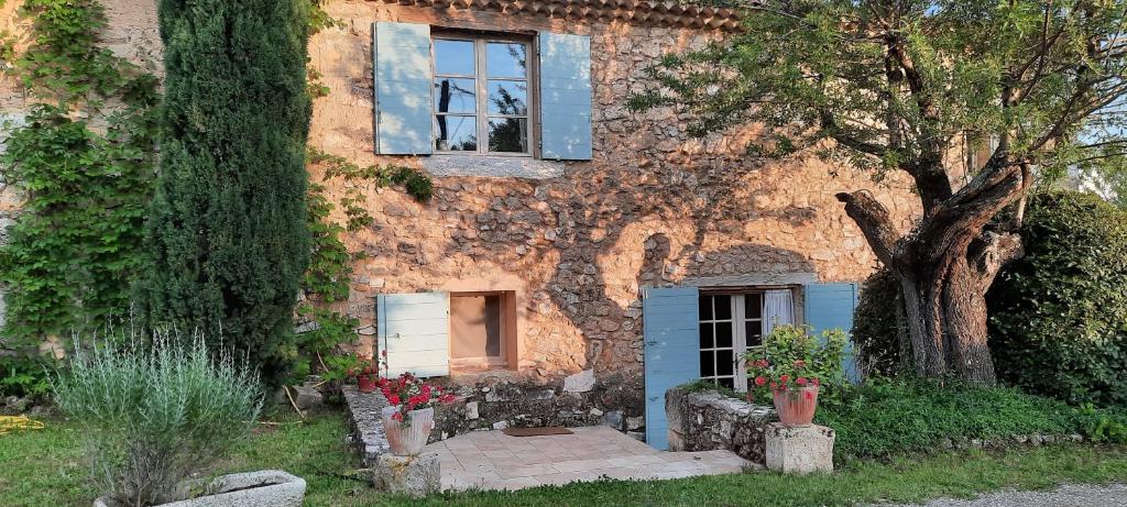 BaudinardGîte Les Fourches的一座石头房子,有窗户和一棵树