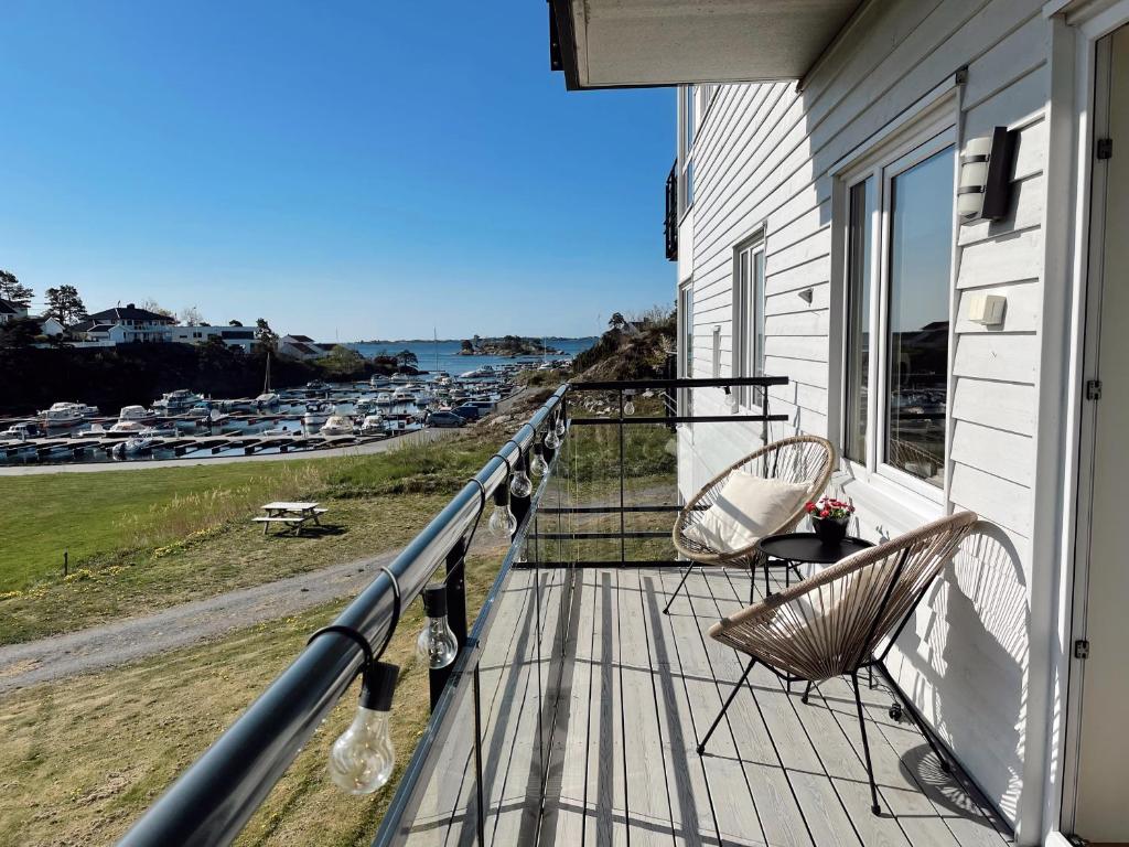 格里姆斯塔Koselig leilighet med balkong og sjøutsikt.的阳台配有椅子,享有水景