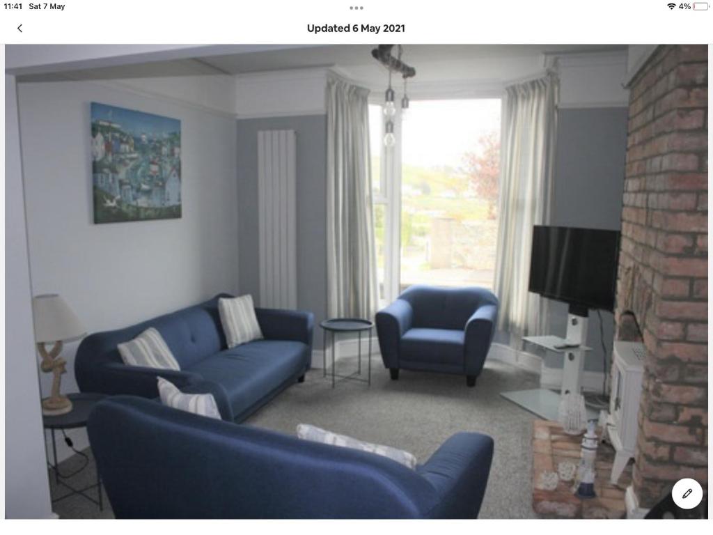 克里基厄斯Beachside holiday house的客厅配有蓝色的沙发和电视