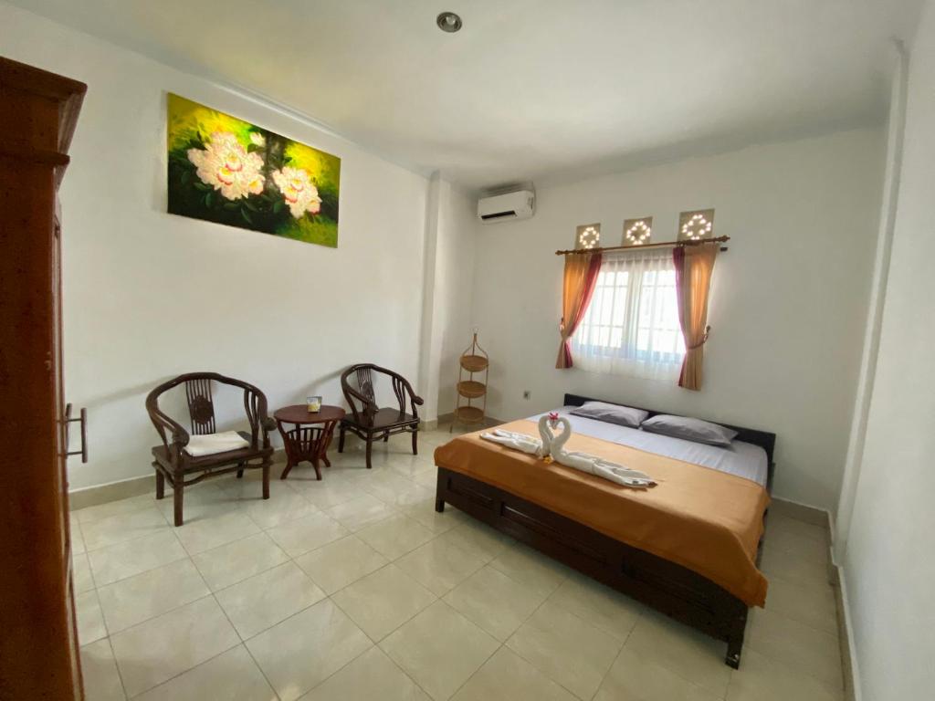 八丹拜庞多敏巴旅馆的卧室配有一张床和一张桌子及椅子