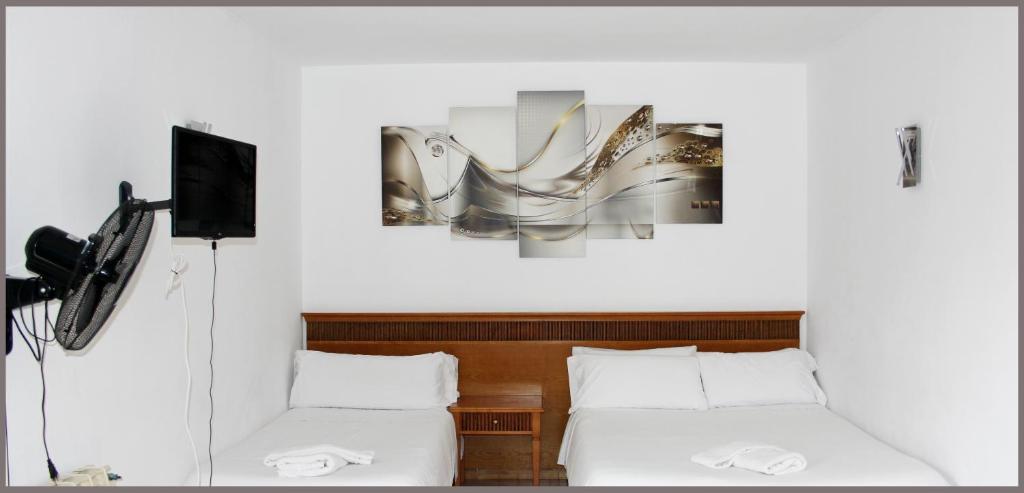 马略卡岛帕尔马戈米拉公园公寓式酒店的酒店客房设有两张床、一台电视和一张图片