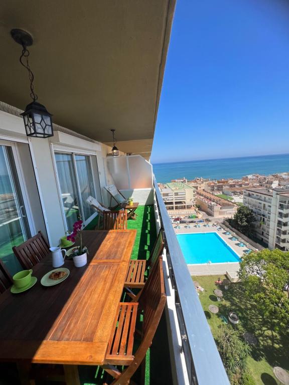 多列毛利诺斯Apartamento Carihuela Torremolinos的阳台设有木桌,享有海景。