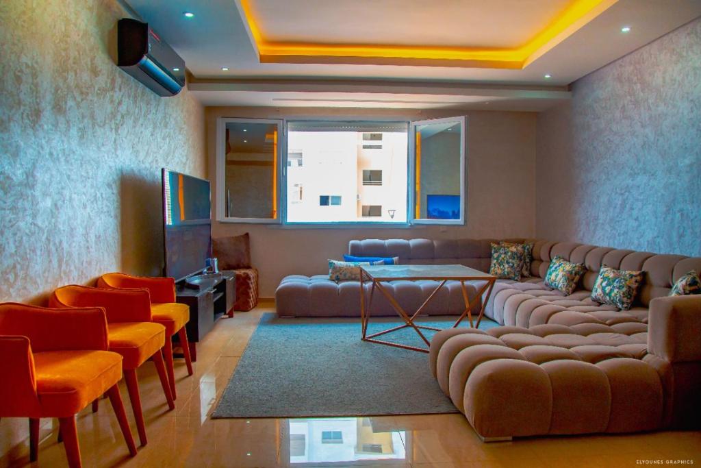 阿加迪尔Islane vue piscine的客厅配有沙发、椅子和电视