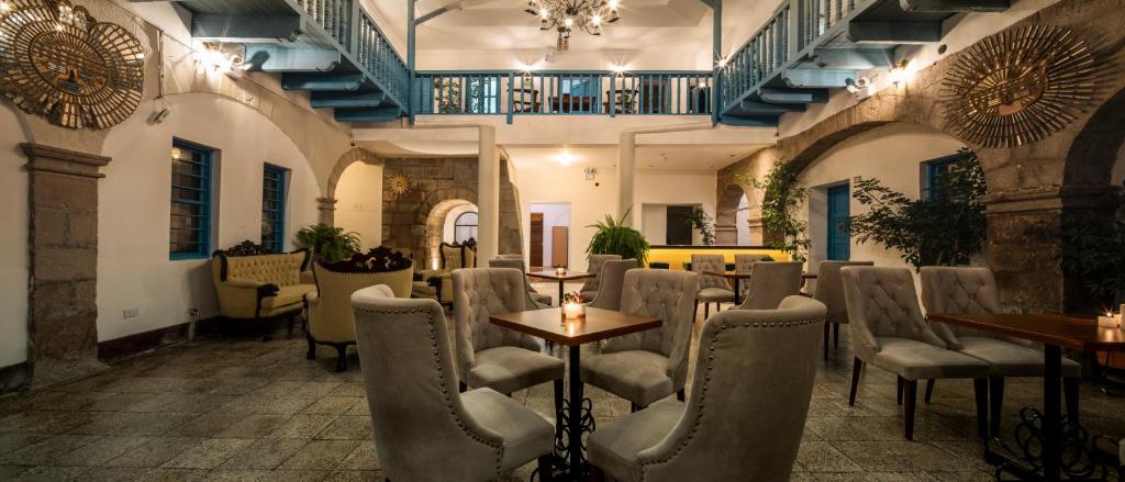 库斯科Hotel Rojas Inn的一间在房间内配有桌椅的餐厅