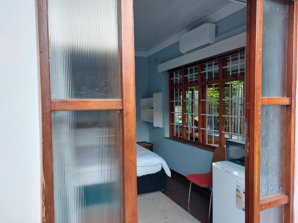 彼得马里茨堡Luvuyos Guest House Pmb的小房间设有床和窗户