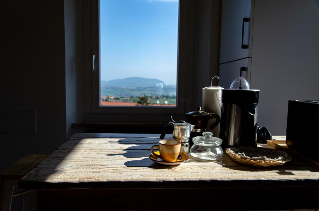 雷卡纳蒂Finestra sul mare的一张桌子,上面有咖啡杯,有窗口