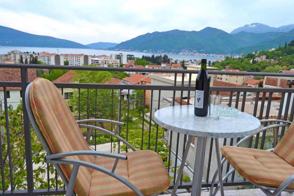 蒂瓦特Tivat Apartments的阳台上的桌子上摆放着一瓶葡萄酒
