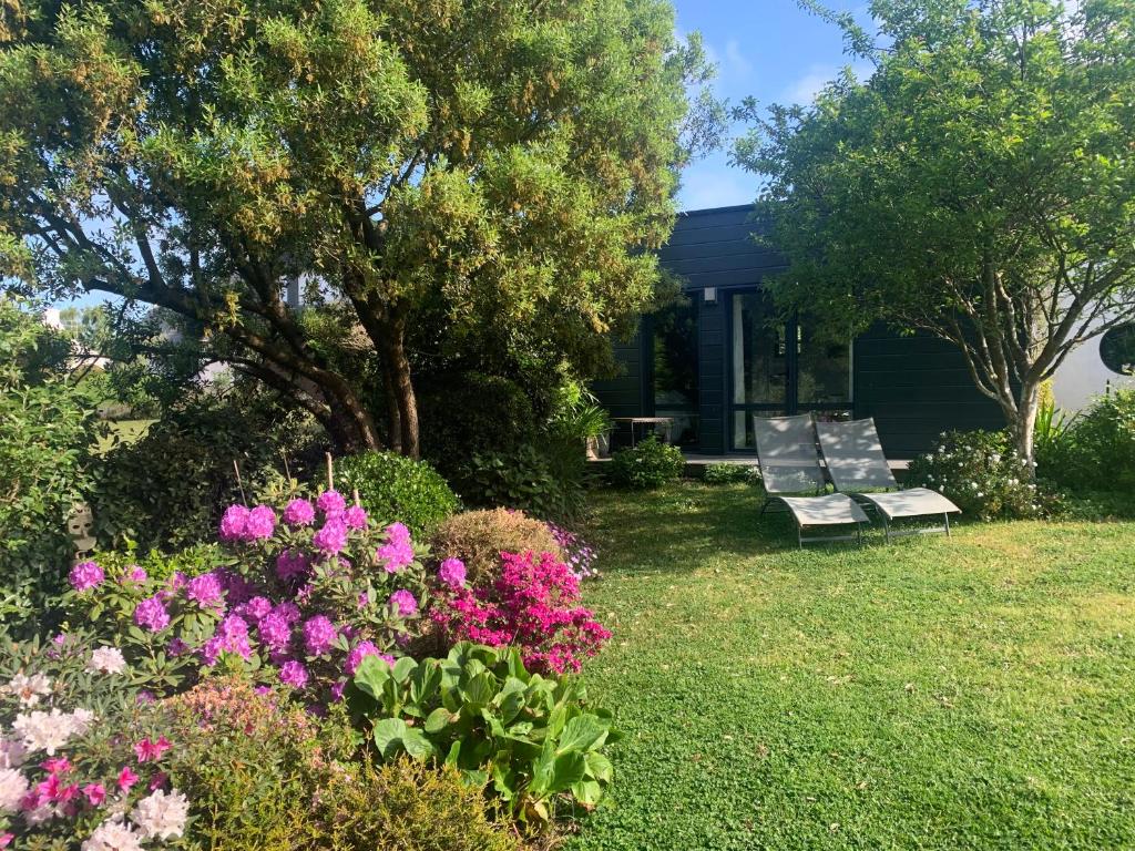 阿拉东Ker Mouettes的鲜花盛开的花园,房子前面的长凳