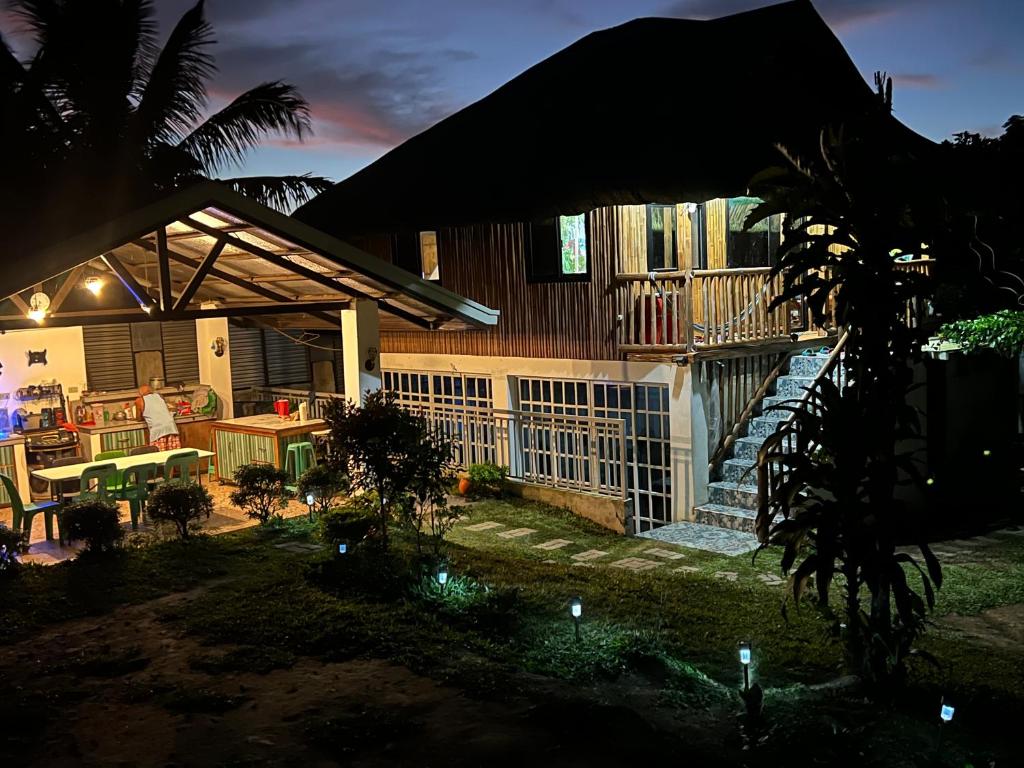 锡朗Bahay Kubo ZaiLaiH的一座房子,在晚上设有庭院和门廊