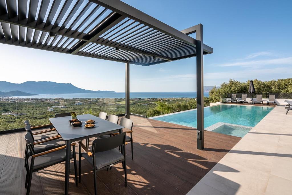 基萨莫斯Villas Phos and Kallos的一个带桌椅的庭院和一个游泳池