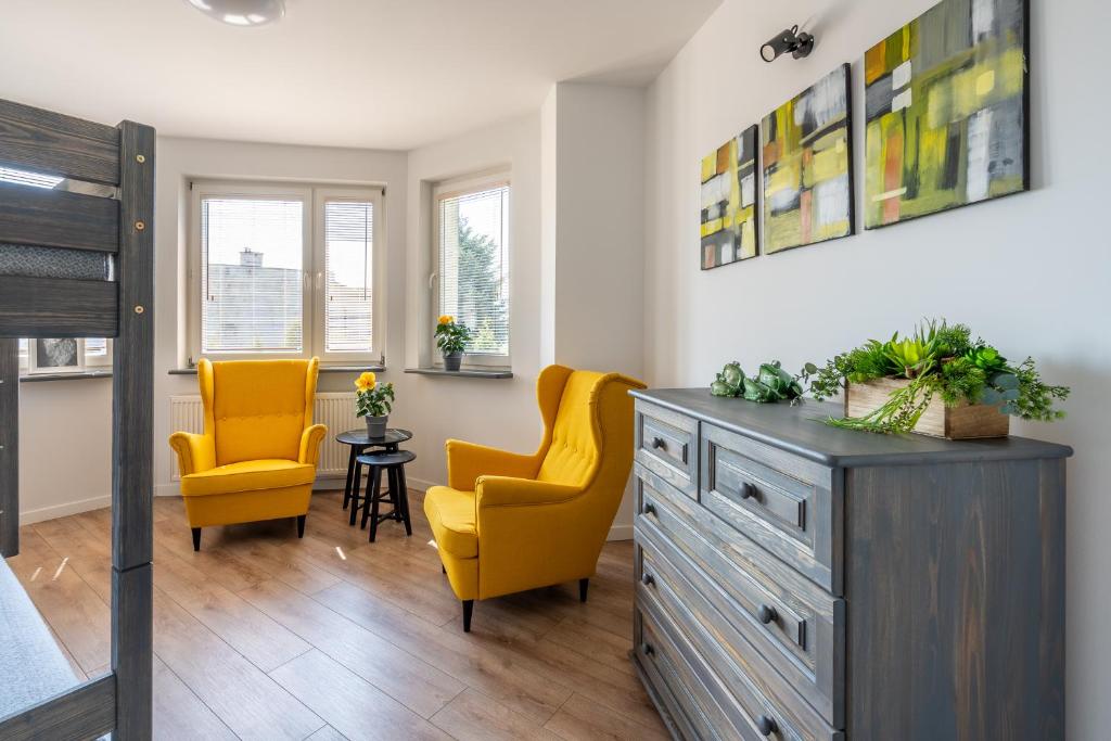 奥斯威辛Apartament Nad Różami的卧室配有2把黄色椅子和梳妆台