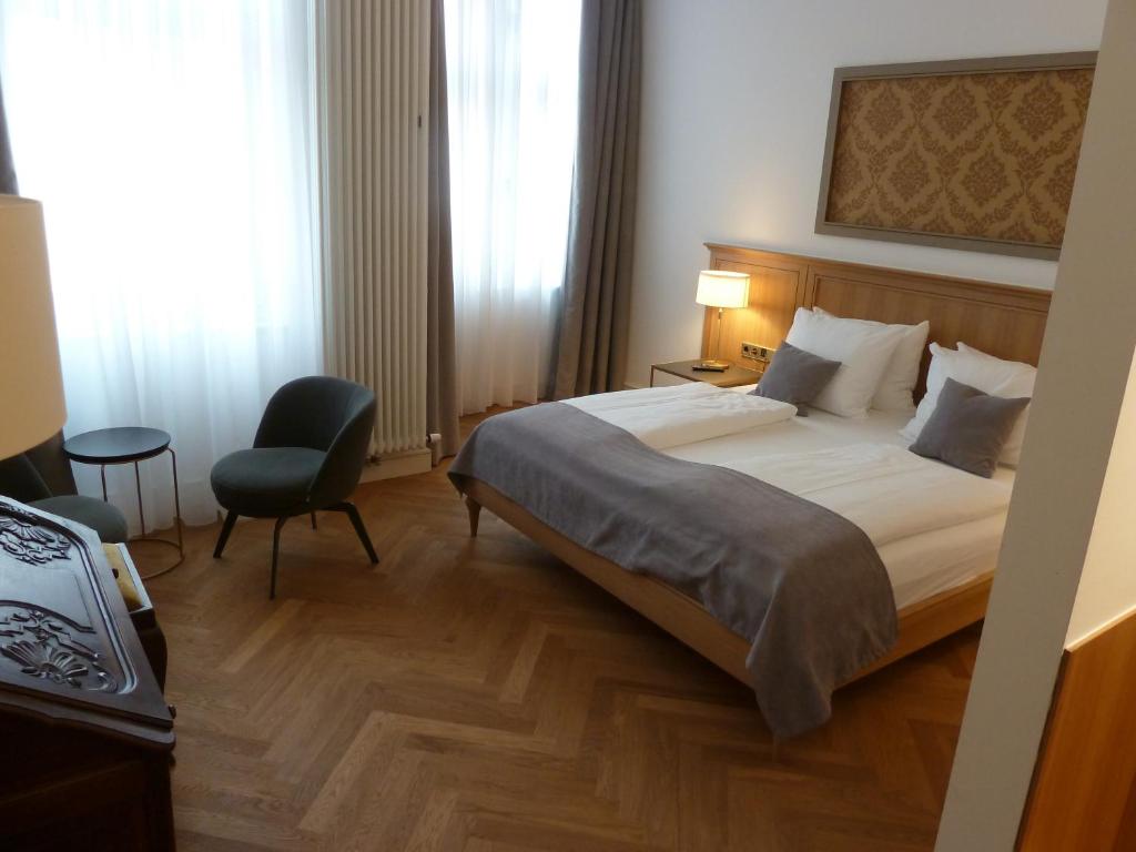 柏林林登乌法酒店的配有一张床和一把椅子的酒店客房