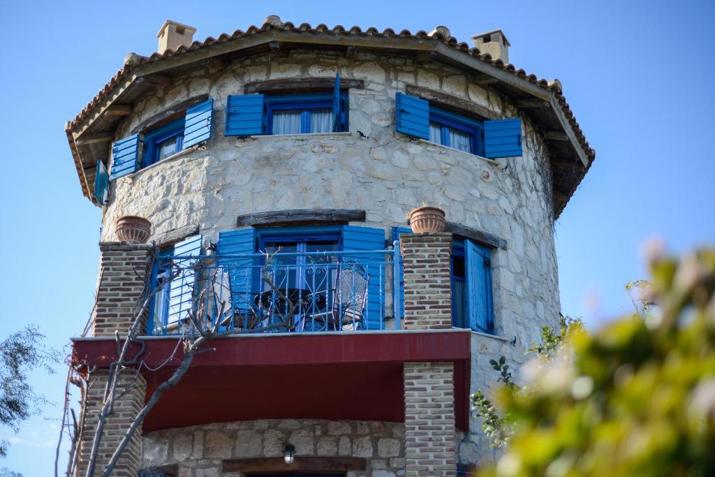 瓦西里科斯Valory's Houses - The Tower的拥有蓝色窗户和阳台的建筑
