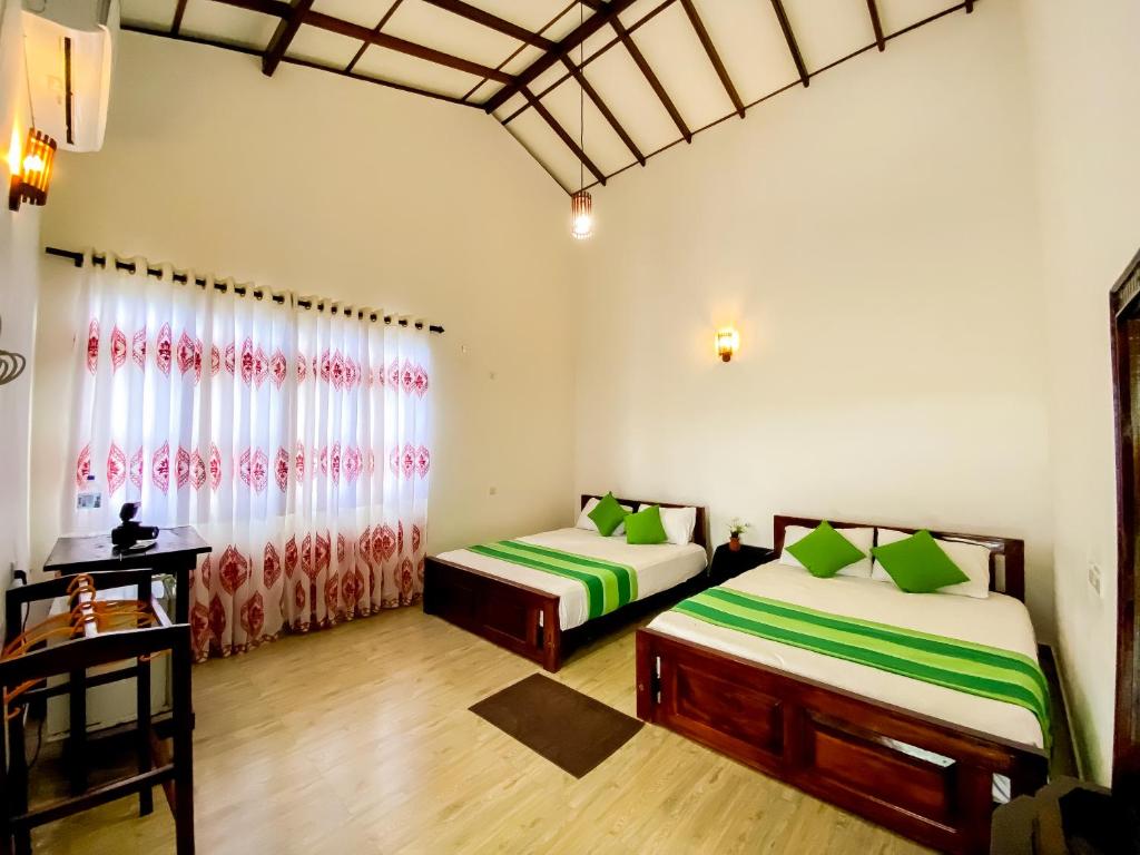 蒂瑟默哈拉默Lavender Home Yala Safari的一间卧室设有两张床和窗户。