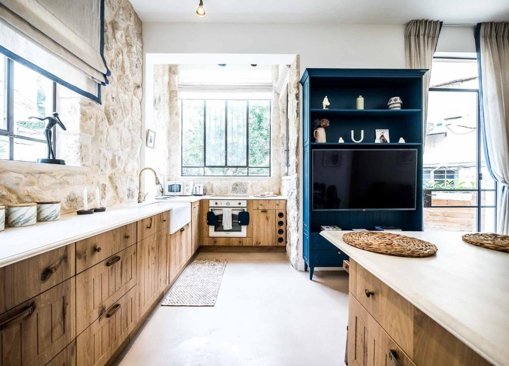 特拉维夫VELLER Mapu的一个带木制橱柜和大窗户的厨房