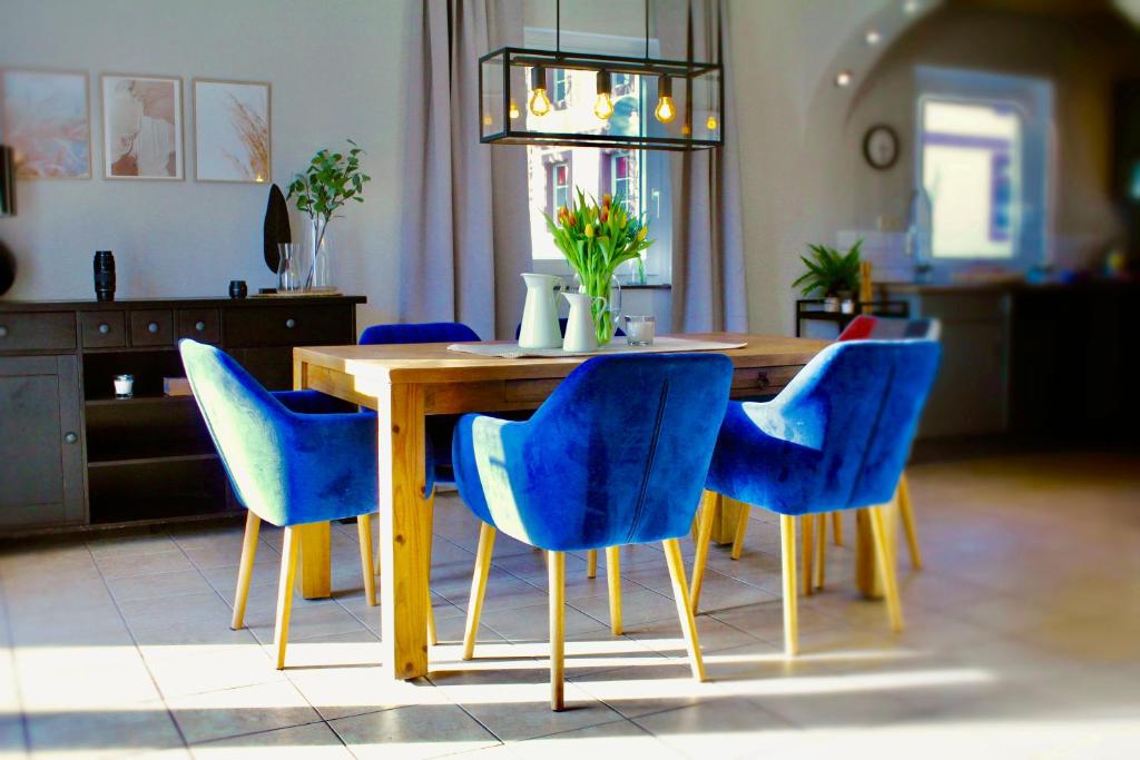 圣温德尔Ferienhaus CLARNI的周围设有一张带蓝色椅子的餐桌