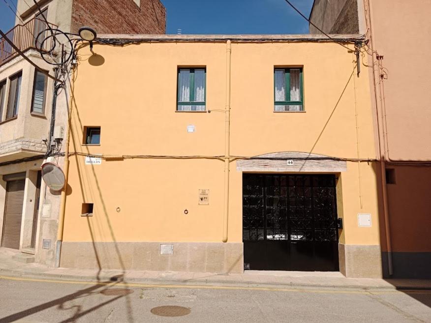 佩雷拉达Can Pitu Ferrer的街道上一座黄色建筑,设有车库