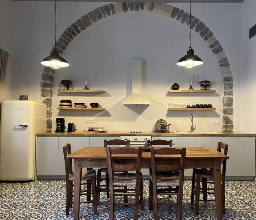 伊兹拉Mercato Vecchio House的厨房配有桌椅和拱门