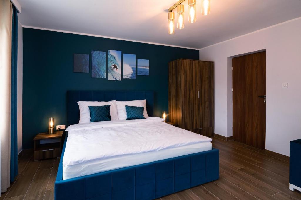 BrwinówApartament Zielony Przylądek的一间卧室设有一张蓝色墙壁的大床