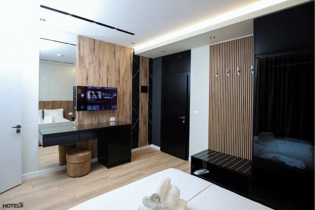 伏罗拉Hotel Three的一间卧室配有一张床和一台电视。