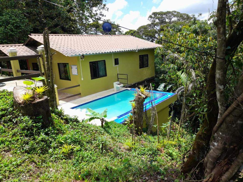 塞罗阿苏尔Tu casa de campo, Menus de la Montaña, te espera的黄色的房子,前面有一个游泳池