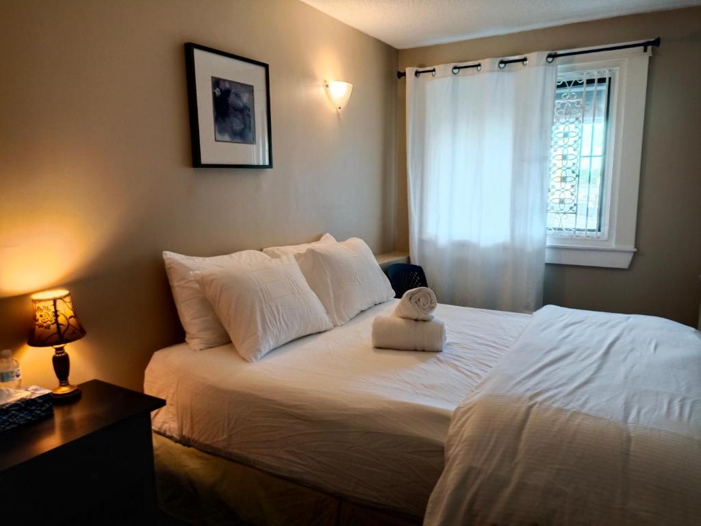 纳奈莫锦龟宾馆的卧室配有一张大白色床和窗户