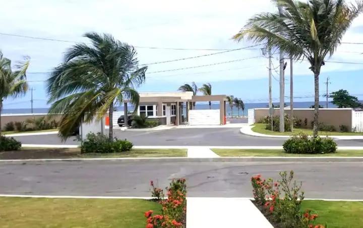 卢西Hamilton @ Oceanpointe a serene 2bed 2 bath Villa的街道前有棕榈树的房子