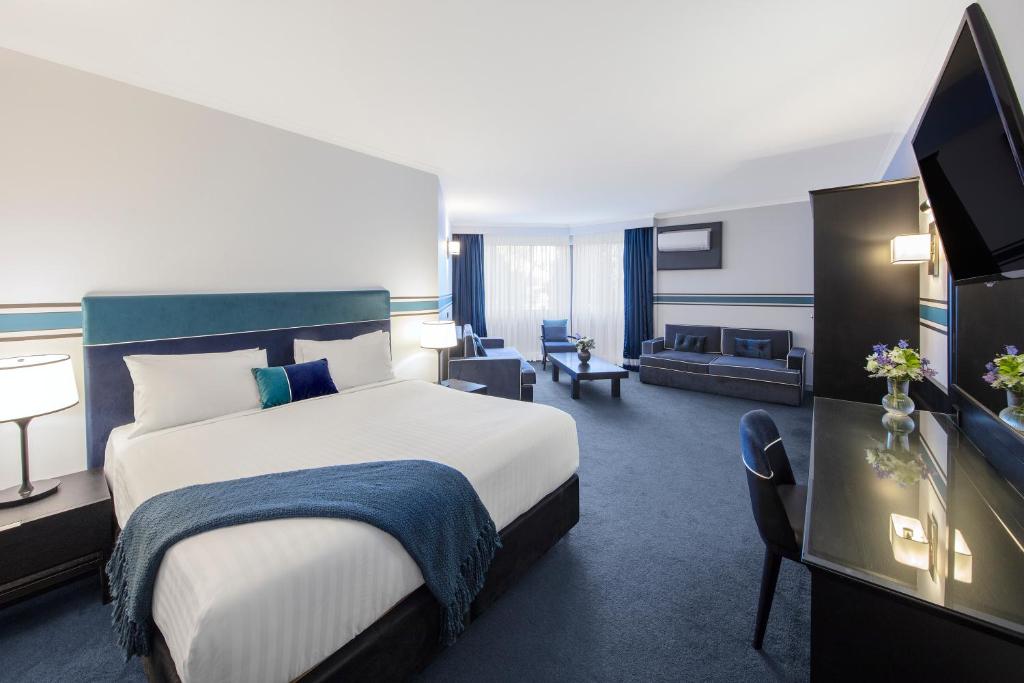 堪培拉Ramada Diplomat Canberra的酒店客房设有床和客厅。