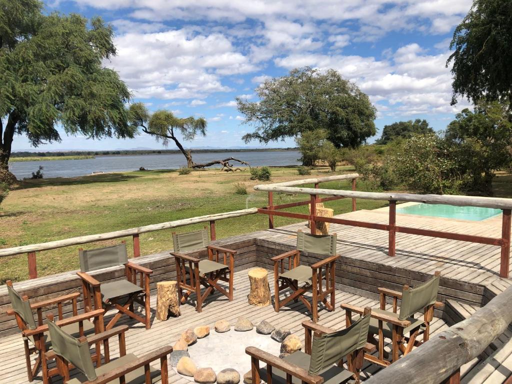 MafutaBubezi Camp的一个带桌椅的甲板和一个游泳池