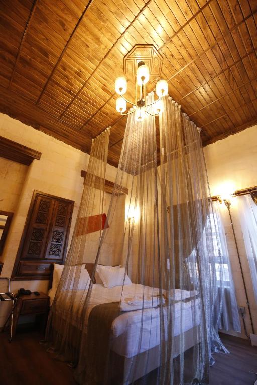 尚勒乌尔法Kaliruha Boutique Hotel的一间卧室配有一张带蚊帐的床