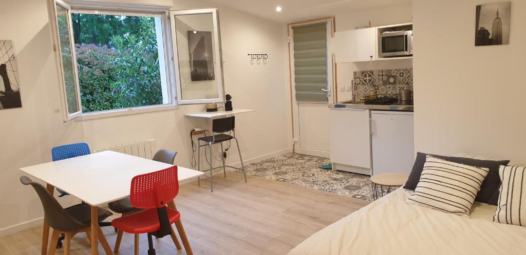 马赛Adorable studio 25m² très calme avec parking的小房间设有一张床、一张桌子和椅子