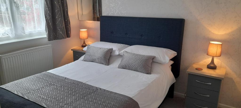 桑当Little Parklands的一间卧室配有一张带枕头的床和两盏灯。