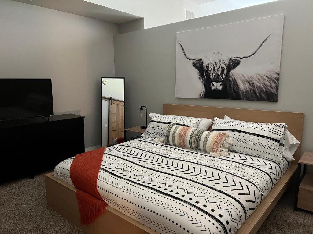 诺福克Downtown Norfolk Loft的卧室配有一张床,墙上挂着一头奶牛