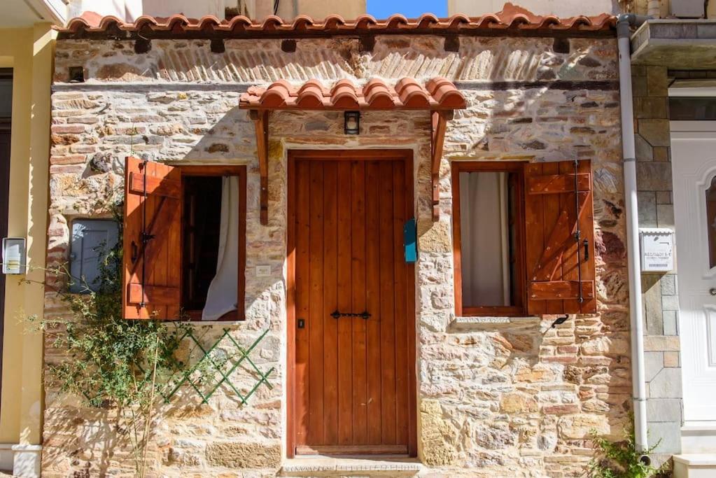 拉夫里翁Lavrio stone house 5 min from the centre/port的石屋,设有木门和两扇窗户