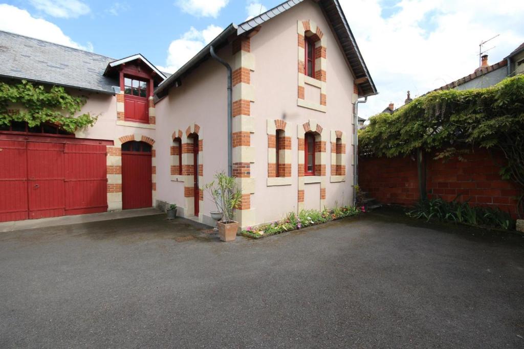 波格思莱丝奥克Le Faré Pouguois的白色的房子,有红色的门和车道