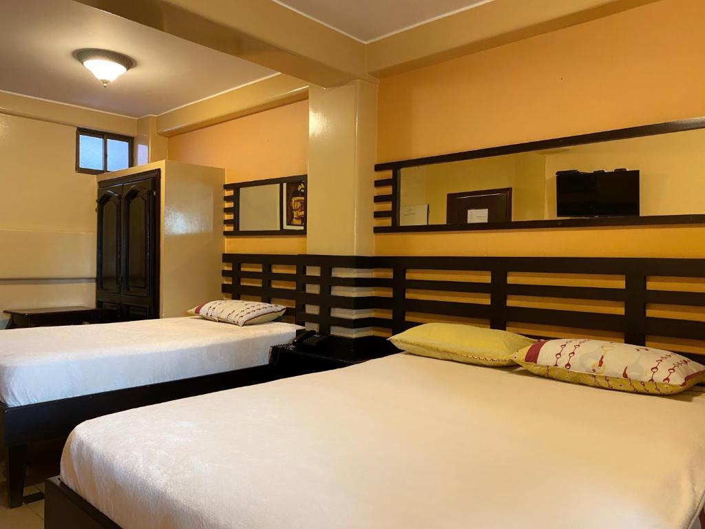 瓜亚基尔Hostal Montesa的一间卧室配有两张床和镜子