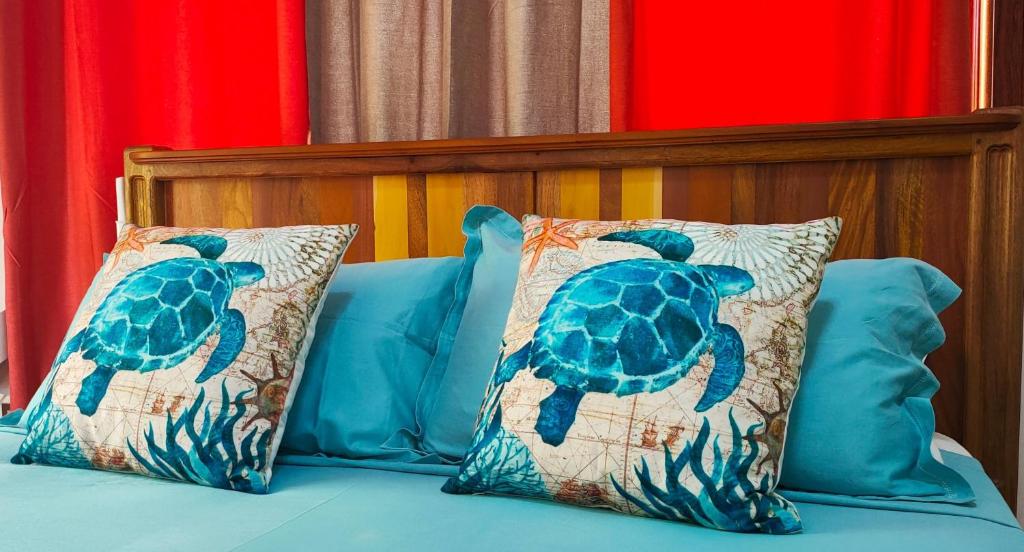 拉迪格岛MT Seaside Apartment的一张带两个枕头的床,上面有乌龟