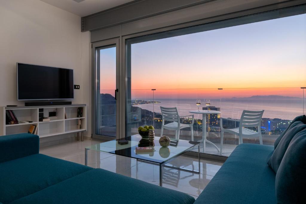 依克希亚Rhodes SkyLine Suites的客厅配有蓝色的沙发和玻璃桌