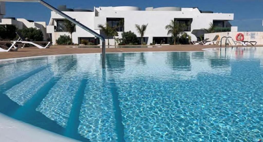 维拉韦德Suite Dreams Fuerteventura的大楼前的大型游泳池