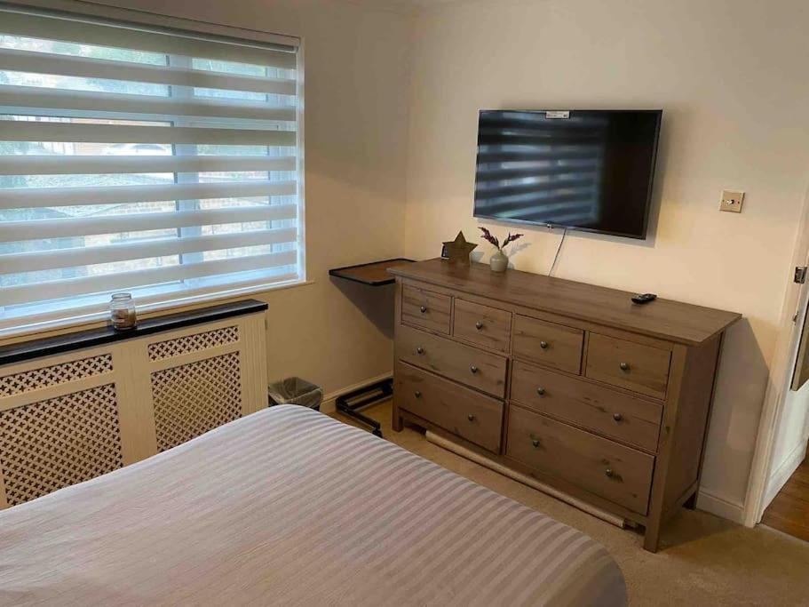 达特福德One bed cozy flat的卧室配有梳妆台和平面电视。