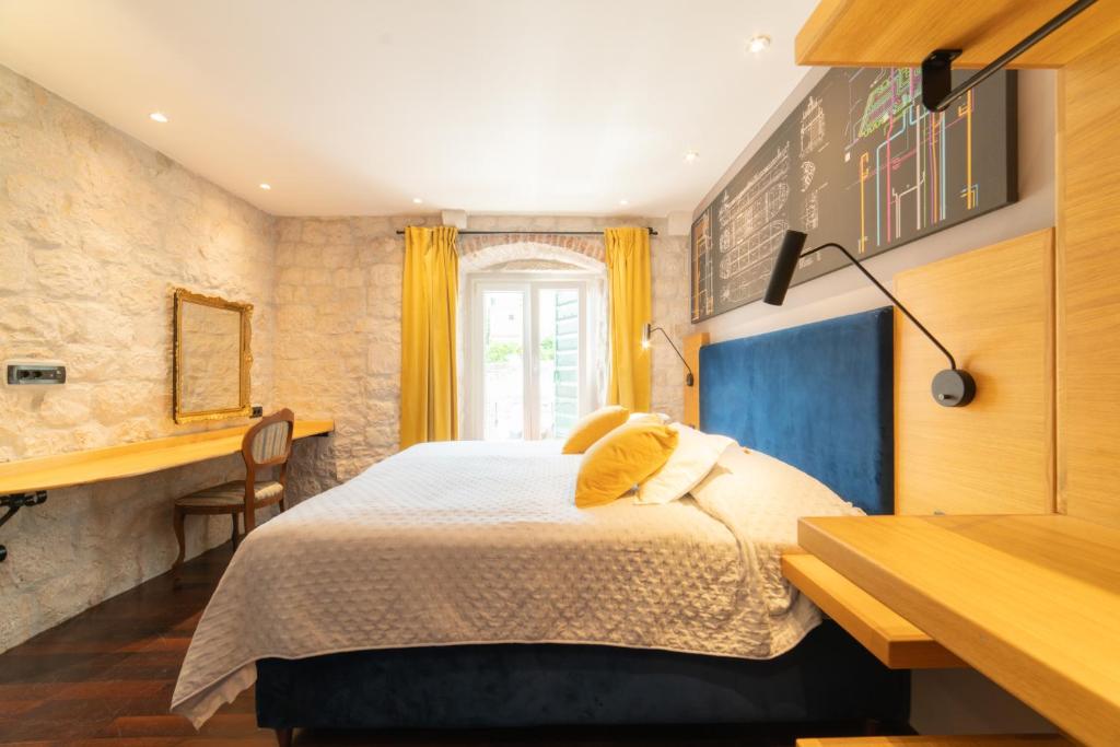 特罗吉尔多姆斯马里蒂玛酒店的一间卧室配有一张床、一张书桌和一个窗户。