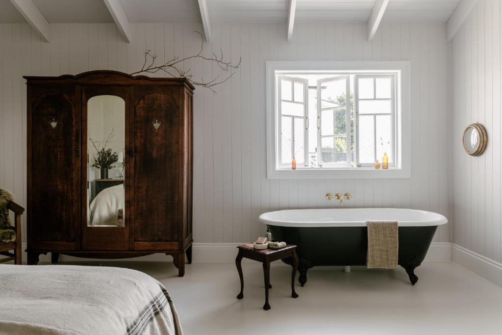 马莱尼墨兰莉小屋酒店的带浴缸和镜子的浴室以及一张床