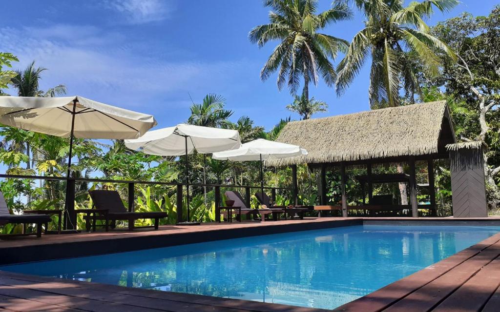 克罗托格Kaila Na Ua Resort的度假村的游泳池配有遮阳伞和椅子